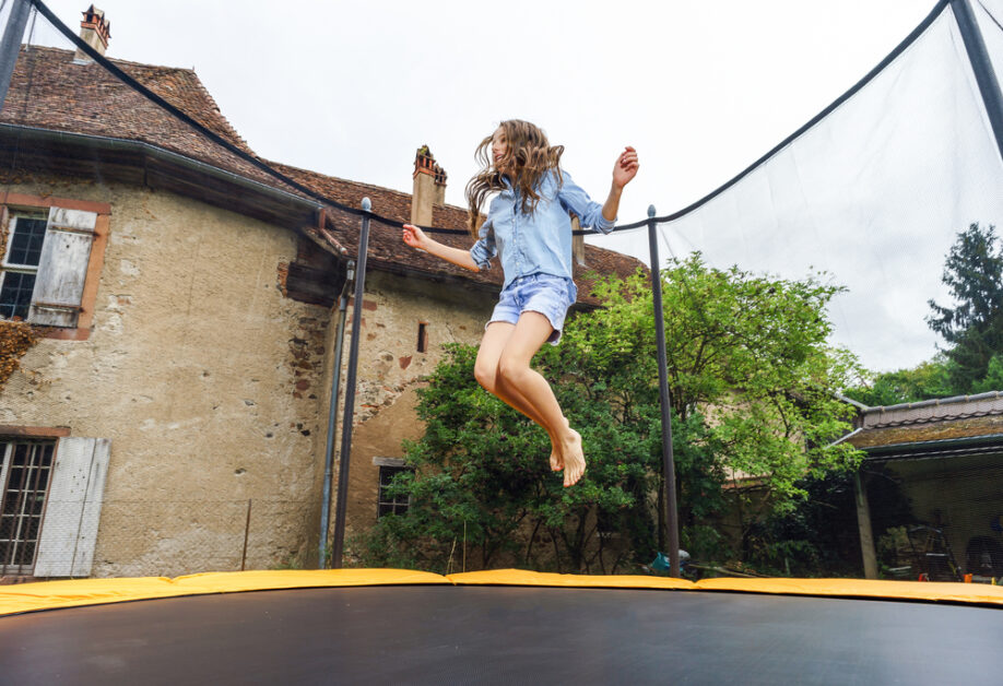 jeune femme sautant sur un trampoline de jardin